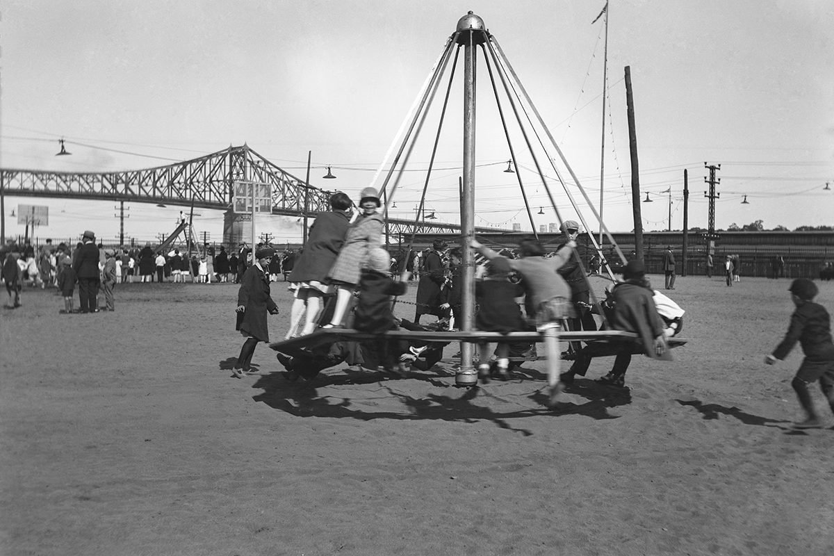 Harry Sutcliffe, <i>Enfants sur un tourniquet dans un parc près du pont Jacques-Cartier</i>, Montréal, vers 1935, négatif inversé (12,5 × 17,9 cm), don de Peter, Paul, Robert et Carolyn Sutcliffe, Musée McCord, M2011.64.2.202